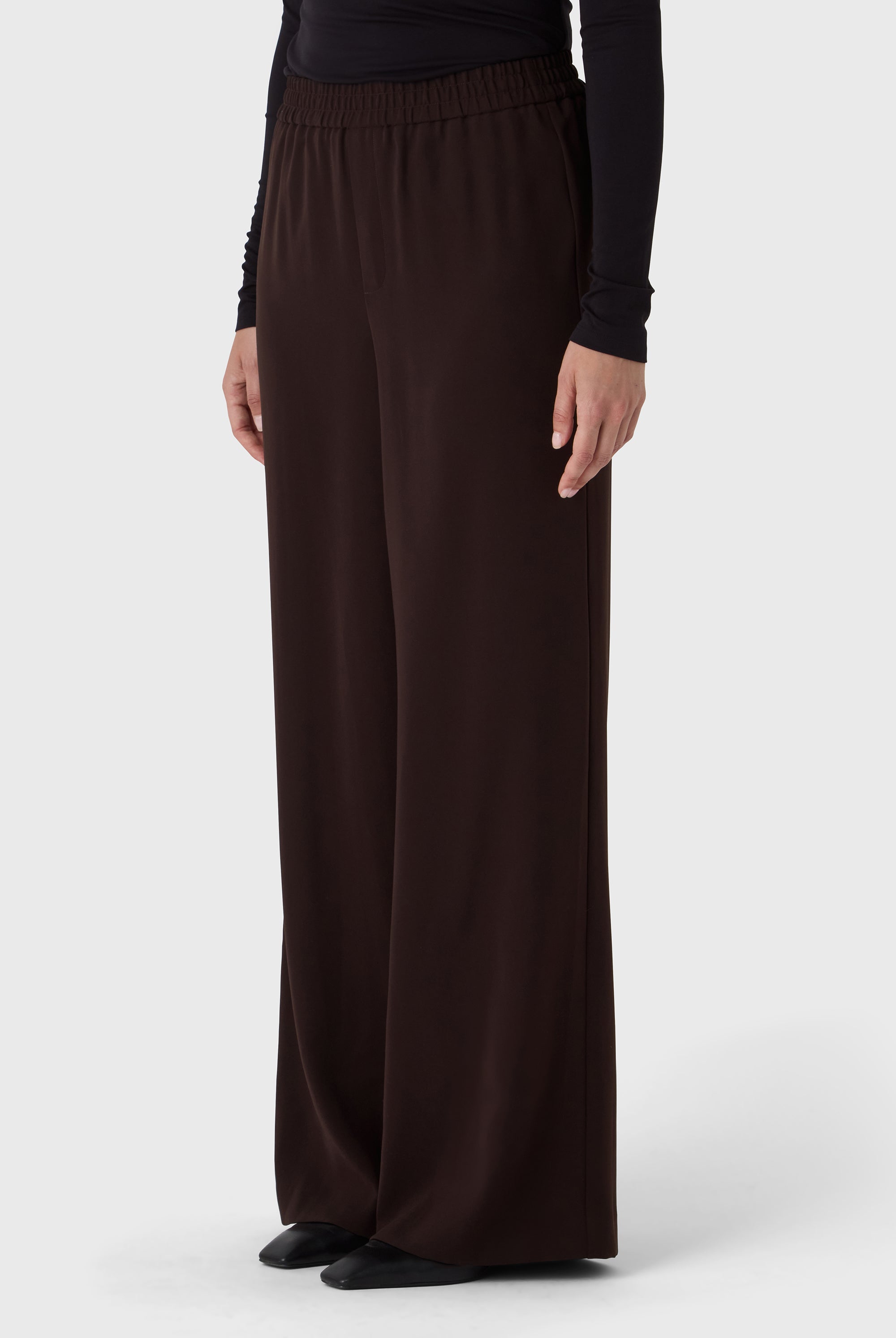 Brown wide-leg pants worn by a person on a white background